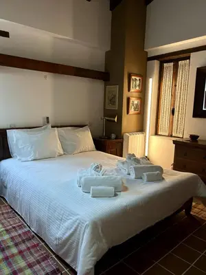 a bedroom with a large white bed with towels on it at FIKARDOU ALMOND PARK in Phikardhou