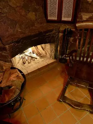 a stone fireplace with a chair in front of it at FIKARDOU ALMOND PARK in Phikardhou