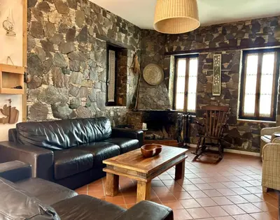 a living room with a leather couch and a table at FIKARDOU ALMOND PARK in Phikardhou
