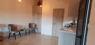 a small kitchen with two chairs and a table at Village Gem Peledri Studio in Pelendri