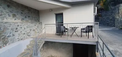 a house with a balcony with two chairs on it at Chic Elegance Meets Village Gem in Pelendri