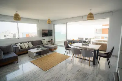 a living room with a couch and a table at Seaview Pearl in Mackenzie with Pool & Jacuzzi in Larnaka