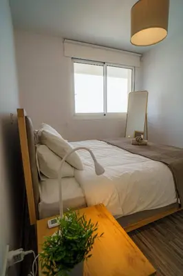 a bedroom with a bed and a table and a window at Seaview Pearl in Mackenzie with Pool & Jacuzzi in Larnaka