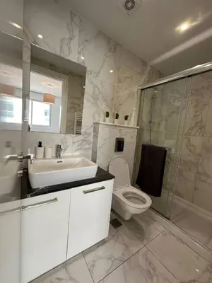 a bathroom with a sink and a toilet and a shower at Seaview Pearl in Mackenzie with Pool & Jacuzzi in Larnaka