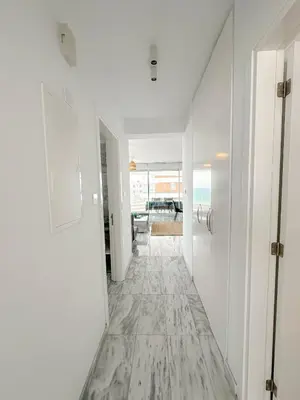 an empty hallway with white walls and a marble floor at Seaview Pearl in Mackenzie with Pool & Jacuzzi in Larnaka