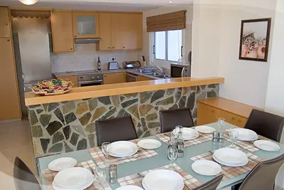 a dining room table with plates and chairs in a kitchen at Anastasia in Pissouri