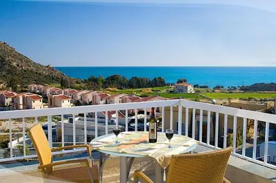 a table with a bottle of wine on a balcony at Anastasia in Pissouri