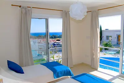 a bedroom with a bed and a large window at Anastasia in Pissouri