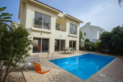 a villa with a swimming pool in front of a house at Villa Cliantha in Protaras