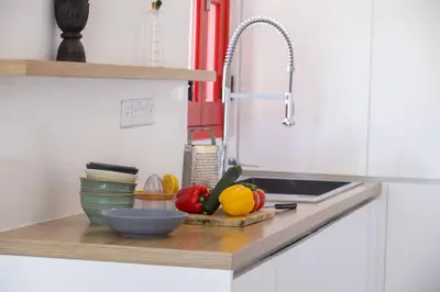 a kitchen counter with fruits and vegetables on a cutting board at Liora Suite in Protaras