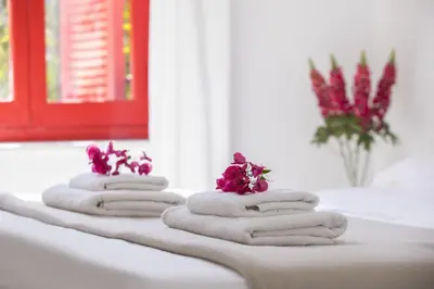 four towels with flowers on them on a bathroom counter at Liora Suite in Protaras
