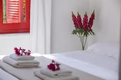 a group of towels and a vase of flowers on a table at Liora Suite in Protaras
