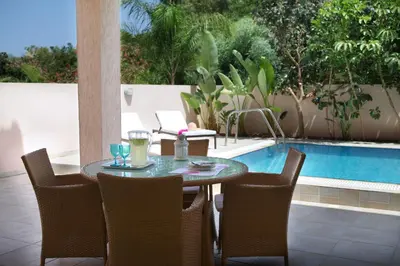 a table and chairs next to a swimming pool at Michelle 8 in Protaras
