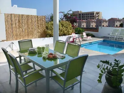a table and chairs on a patio next to a pool at Architect's Villa in Protaras