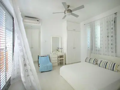 a white bedroom with a bed and a window at Architect's Villa in Protaras