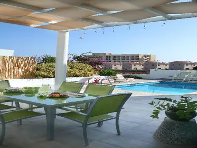 a table and chairs on a patio next to a pool at Architect's Villa in Protaras