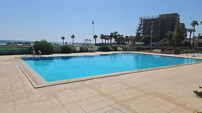 a large swimming pool with blue water at Julie's beach house in Voroklini