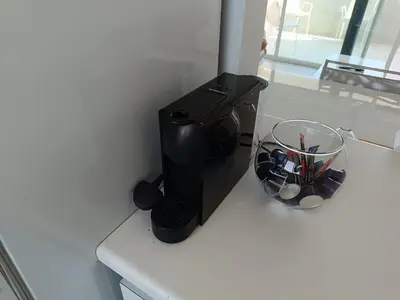 a coffee maker on a counter next to a bowl of pens at Julie's beach house in Voroklini