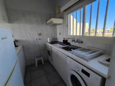a kitchen with a sink and a washing machine at Julie's beach house in Voroklini