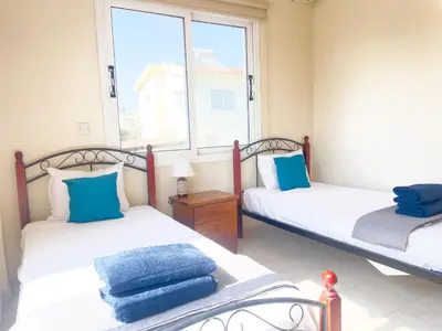 two beds in a room with two windows at Sunset Pearl Holiday Villa in Ayia Napa