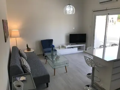 a living room with a couch and a tv at Themis Beach Apartments in Larnaka
