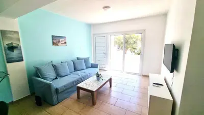 a living room with a blue couch and a table at Dream Escape Apt 1 - 6 min walk to Kastella Beach! in Larnaka