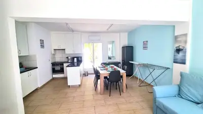 a kitchen and living room with a table and chairs at Dream Escape Apt 1 - 6 min walk to Kastella Beach! in Larnaka
