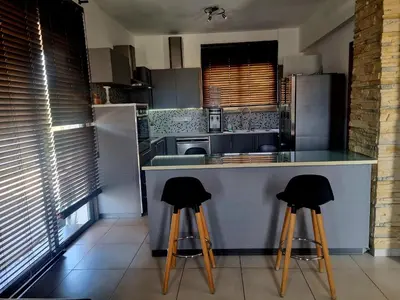a kitchen with two bar stools at a counter at Impeccable 3-Bed Villa in Nicosia in Yukarı Lakatamya