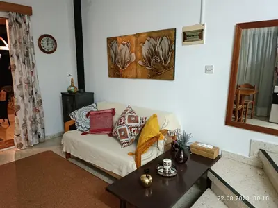 a living room with a white couch and a table at Ferienhaus_FamilyKrausz in Pervolia