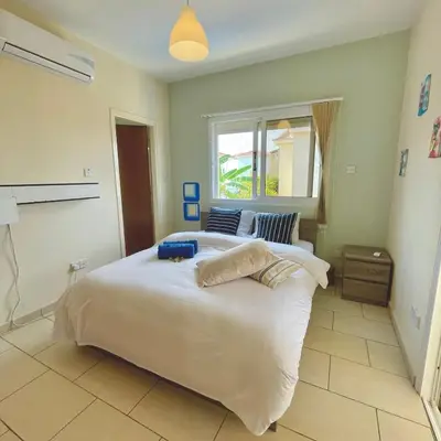 a bedroom with a large white bed and a window at Mediterranean Breeze Villa in Protaras