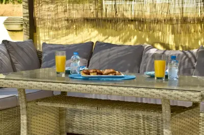 a table with a plate of food and two glasses of orange juice at Mediterranean Breeze Villa in Protaras