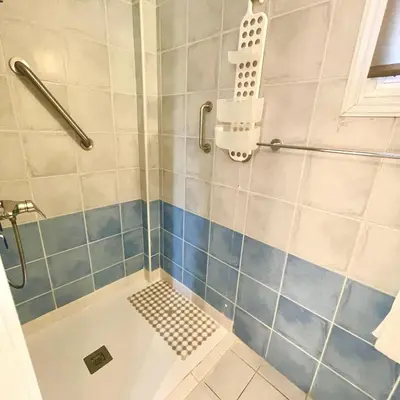 a bathroom with a shower with blue and white tiles at Mediterranean Breeze Villa in Protaras