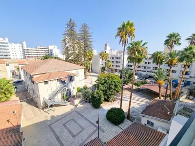 an aerial view of a city with palm trees and buildings at Seaside Elegance Retreat in Larnaka