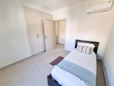 a white bedroom with a bed and white walls at Seaside Elegance Retreat in Larnaka