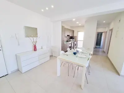 a white dining room with a white table and chairs at Seaside Elegance Retreat in Larnaka