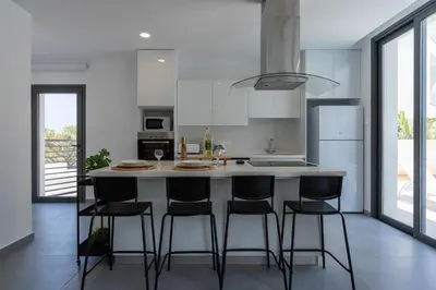 a kitchen with a island with bar stools at Villa Flora's 3-BR Retreat & Private Pool in Protaras in Paralimni