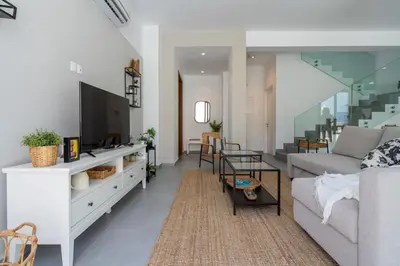 a living room with a couch and a tv at Villa Flora's 3-BR Retreat & Private Pool in Protaras in Paralimni