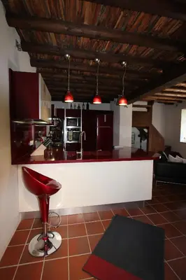 a kitchen with a red stool in a room at River House in Kakopetria