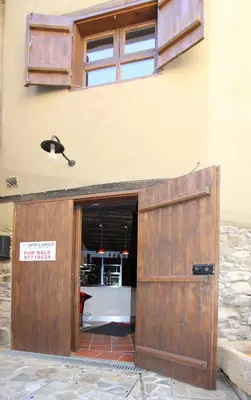 a building with a wooden door with a sign on it at River House in Kakopetria