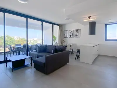 a living room with a couch and a table at Phaedrus Living White Hills Suites Panoramic View in Aglantzia