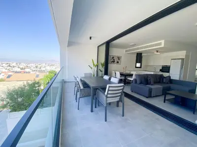 a dining room and living room with a table and chairs at Phaedrus Living White Hills Suites Panoramic View in Aglantzia