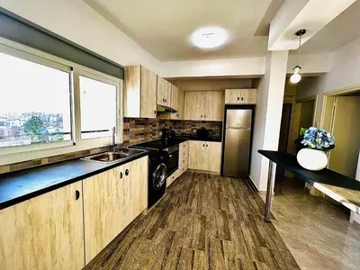 a kitchen with wooden cabinets and a sink and a window at MINA 53 in Larnaka