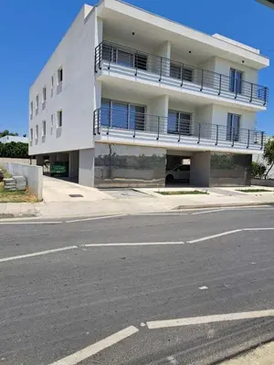 an empty street in front of a white building at Nice flat in Tseri
