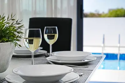 a table with two glasses of white wine on it at Villa Genesis in Protaras