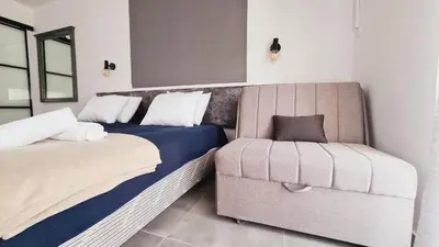 a bedroom with two beds and a chair at Nissi avenue 64 Studio 3 - Luxcyservices in Ayia Napa
