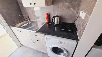 a small kitchen with a washing machine and a sink at Nissi avenue 64 Studio 3 - Luxcyservices in Ayia Napa