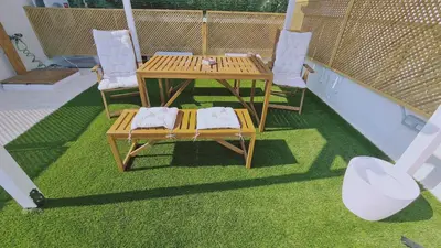 a table and chairs on a balcony with grass at STAY Napa Aura Apartment in Ayia Napa
