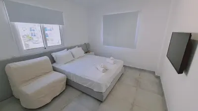 a small bedroom with a bed and a chair at STAY Napa Aura Apartment in Ayia Napa