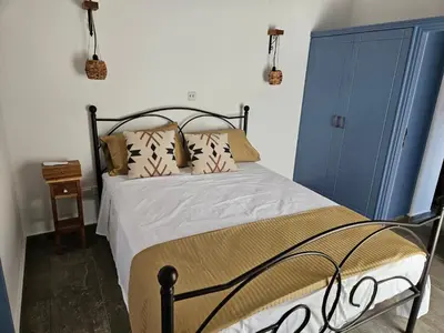 a bedroom with a bed with a blue door at Jennas House in Arakapas