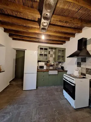 a kitchen with green and white appliances and wooden ceilings at Jennas House in Arakapas